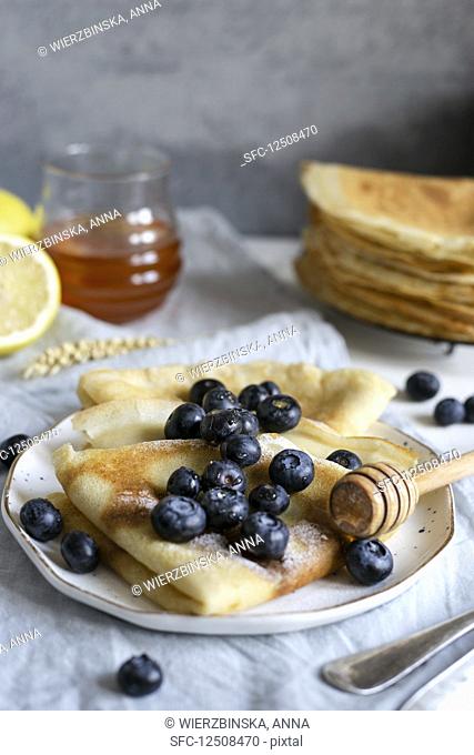 Classic French crepes topped with fresh blueberries and honey