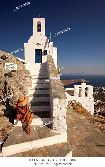 Woman sitting on the stairs of the Agios Constantinos church in Hora, Serifos, Cyclades Islands, Greek Islands, Greece, Europe