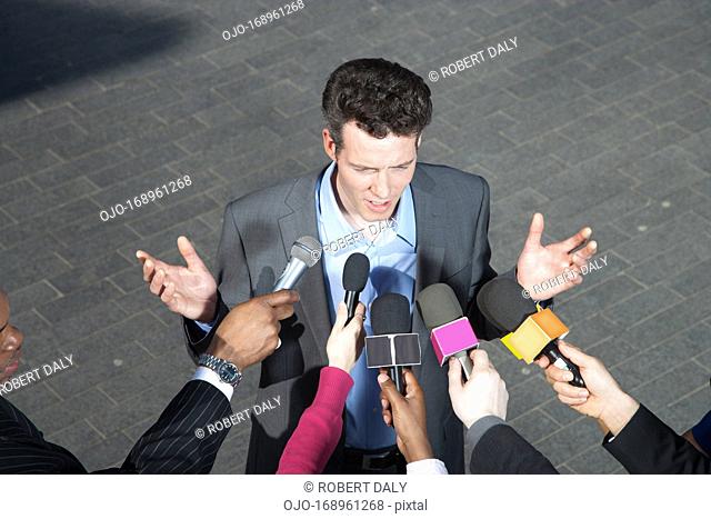 Reporters holding microphones for politician