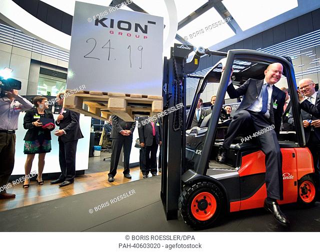 Gordon Riske (2-R), head of German multinational manufacturer of forklifts Kion, poses for the camera with a forklift on the floor of the Stock Exchange in...