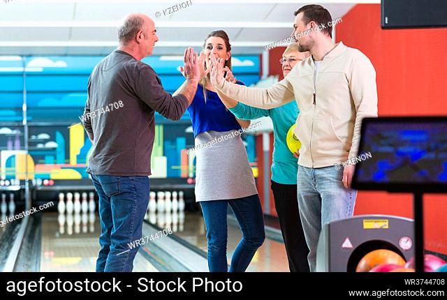 Smiling family enjoying indoor games giving high-five