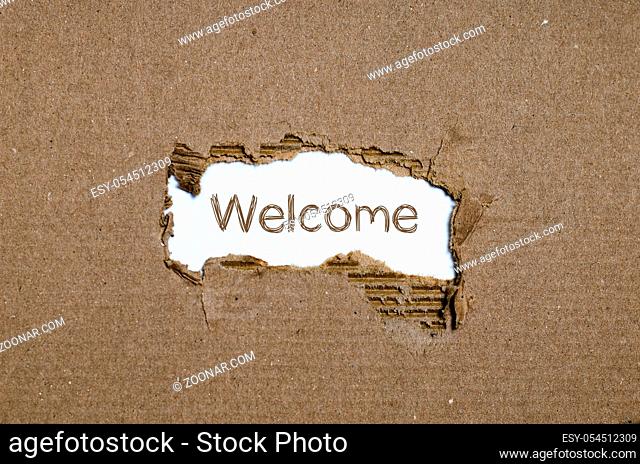 The word welcome appearing behind torn paper