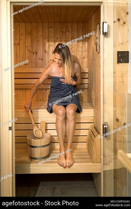 Woman in towel relaxing at sauna