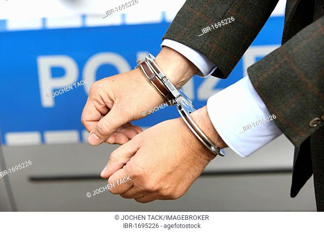 Man in a suit and in handcuffs