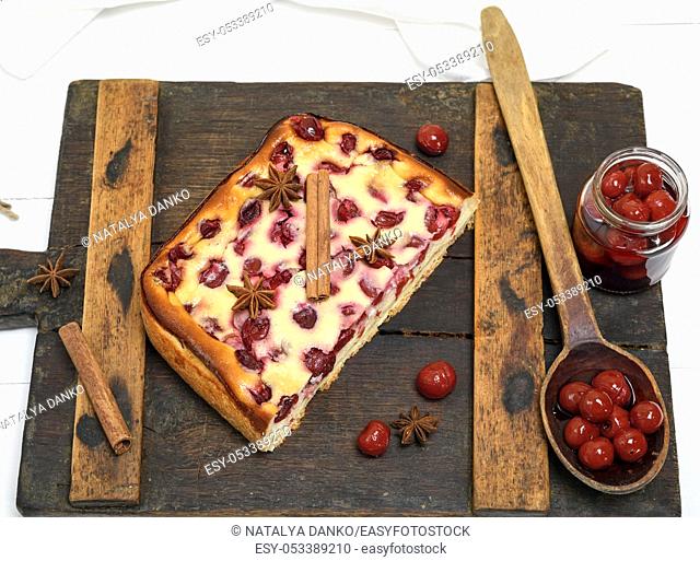 cottage cheese and cherry pie on a brown wooden board, top view