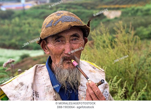 China, Yunnan Province, Kunming Municipality, Dongchuan District, Red lands, Xiguadi, man smoking, peasant shepherd