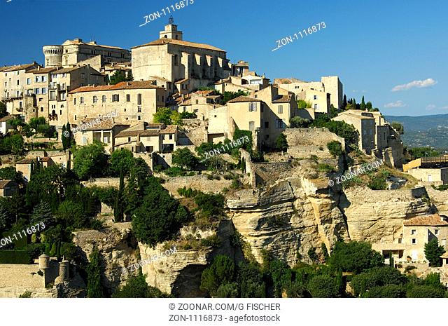 Kleinstadt Gordes mit der Festung und der Kirche Saint-Firmin auf der Hügelkette Monts de Vaucluse, Provence, Frankreich / Gordes with the Château de Gordes and...