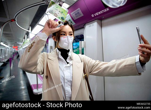 Wearing a mask of the young woman standing in the subway