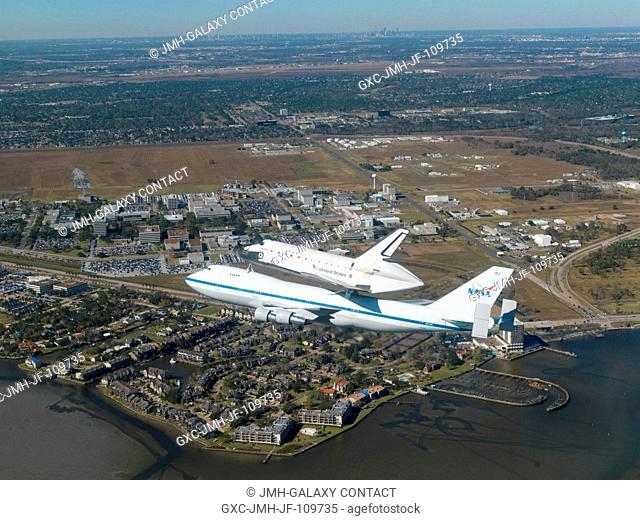 The Space Shuttle Endeavour flies over the Clear Lake area and the Johnson Space Center after having spent the night at a stopover in Tarrant County