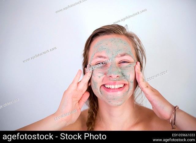 Beautiful young woman with facial mask, beauty treatment