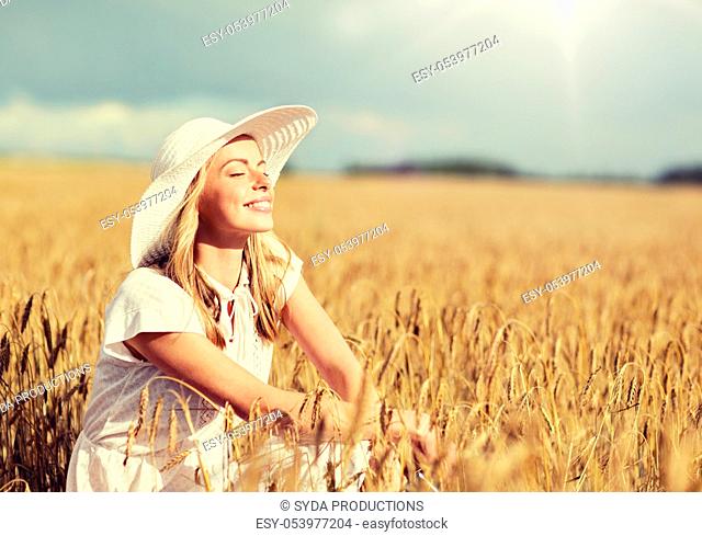 happy young woman in sun hat on cereal field
