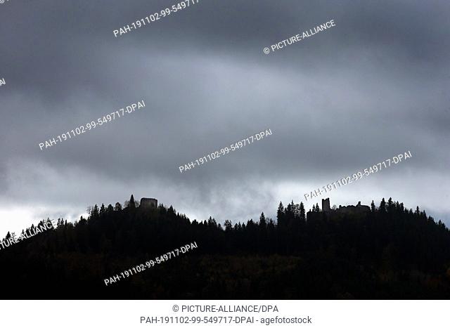 01 November 2019, Bavaria, Pfronten: Under dark clouds stand the castle ruins Eisenberg (l) and Hohenfreyberg. Photo: Karl-Josef Hildenbrand/dpa