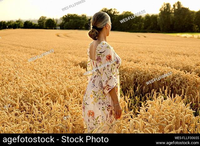 Senior woman standing in wheat field