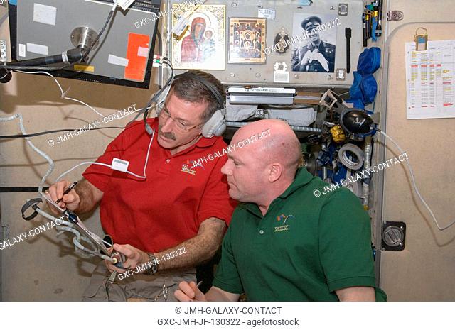 NASA astronaut Dan Burbank (wearing a communication headset), Expedition 30 commander; and European Space Agency astronaut Andre Kuipers, flight engineer