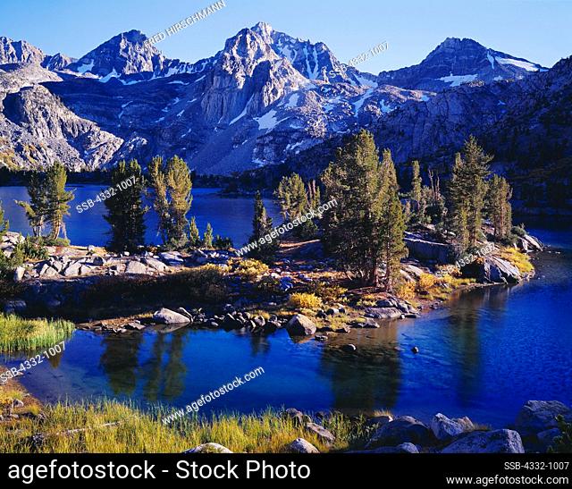 The Painted Lady and Mount Rixford towering above whitebark pines growing along the rocky shore of Rae Lakes, Kings Canyon National Park, California