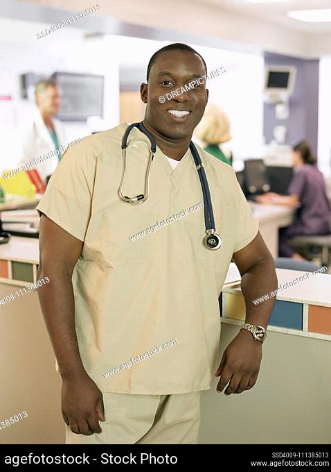 African male doctor leaning on counter