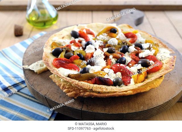 Pane Carasau unleavened Sardinian bread topped with peppers, olives and mozzarella