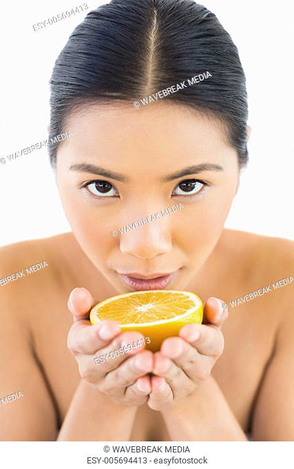 Content pretty woman holding orange in her hands