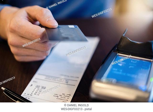 Customer paying bill with credit card, close-up