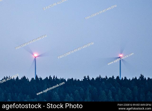 SYMBOL - 15 August 2023, Baden-Württemberg, Spaichingen: Wind turbines rotate in the dark at a wooded area. Photo: Silas Stein/dpa