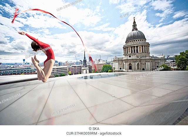 Dancer with ribbon on urban rooftop