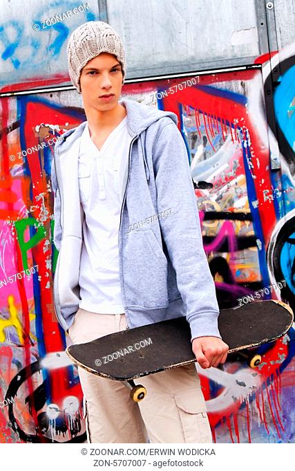 Ein cool blickender Jugendlicher Mann vor Graffiti
