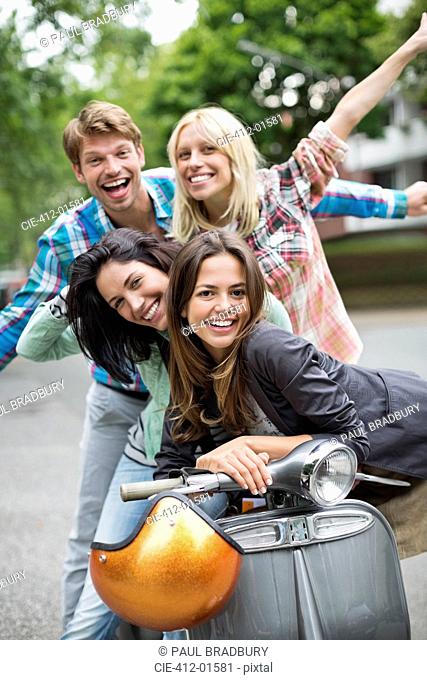 Friends smiling on scooter outdoors