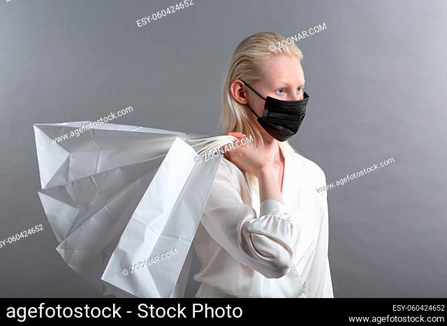 White caucasian albino blond woman holds shopping bag. Sale and discounts on market and Black Friday concept