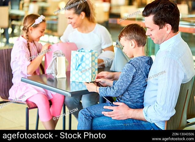 Familie mit Kindern macht eine Pause beim Shopping im Einkaufszentrum