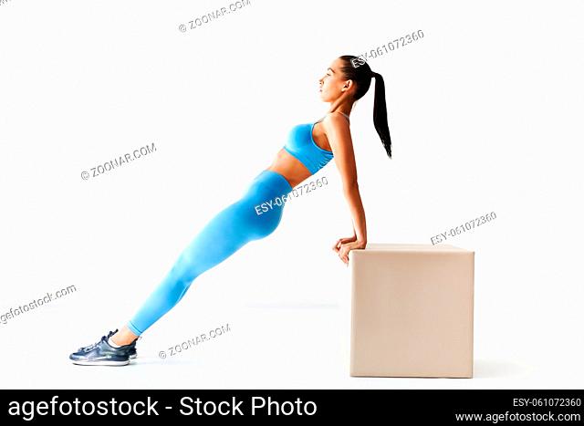 Sporty woman making reverse plank exercise on white background. sport, fitness and people concept