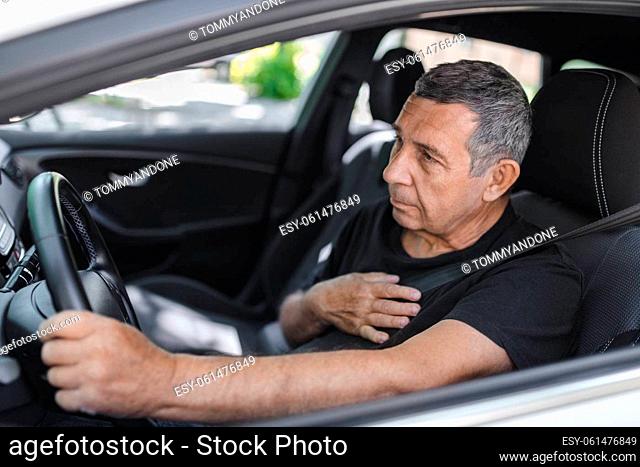 Senior in his 70s, behind the steering wheel with chest pain