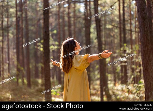woman or witch performing magic ritual in forest