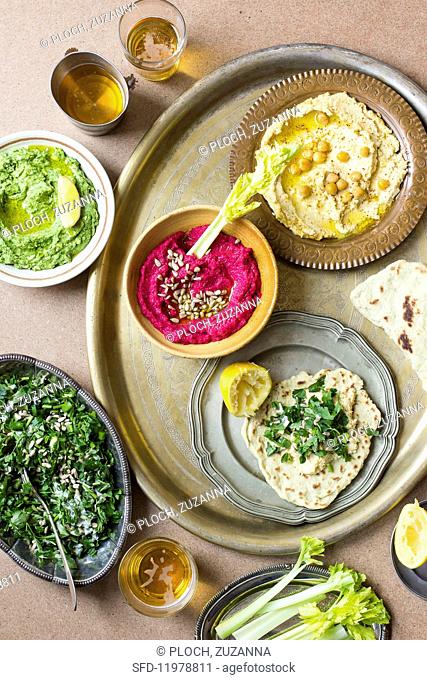 Various types of hummus with lettuce and unleavened bread