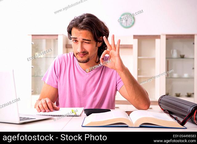 The young male student preparing for exams at home