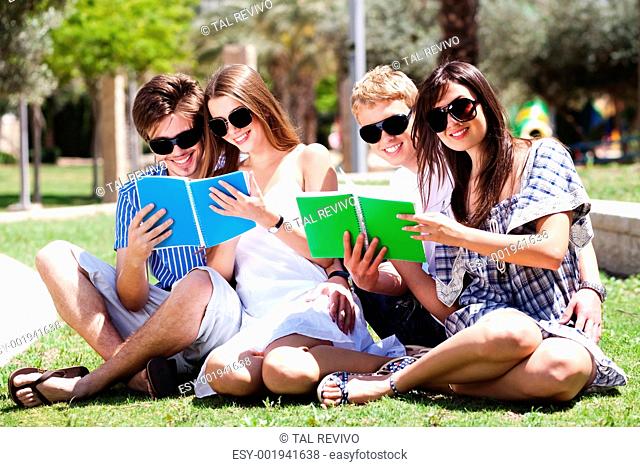 Young couples relaxing in park and reading books