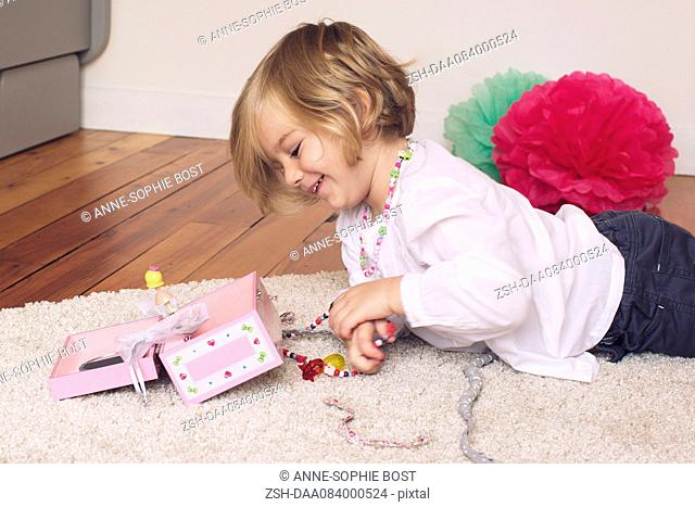 Little girl removing necklace from jewellery box