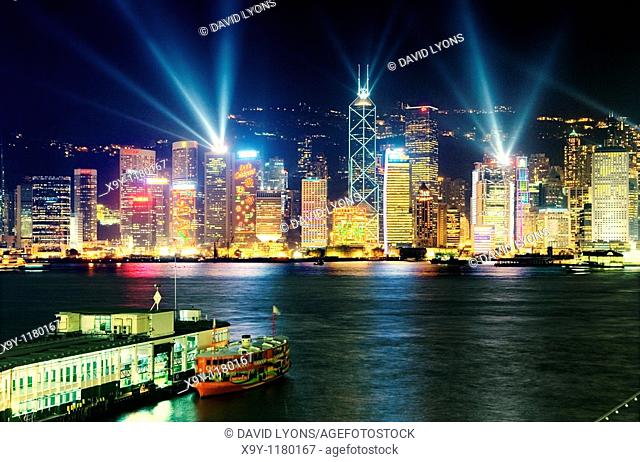 Hong Kong Island China city skyline with night laser light show seen across Victoria Harbour from Kowloon Star Ferry terminal