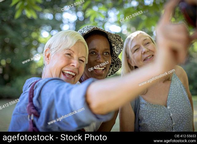 Happy senior women friends taking selfie in park