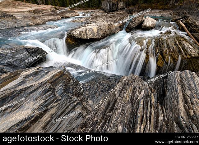 The Kicking Horse River flows down from the mountains, became a waterfall before it goes beneath a natural bridge, Yoho National Park, British Columbia, Canada