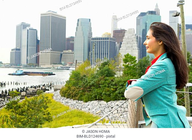Mixed race woman overlooking park and river, New York, New York, United States