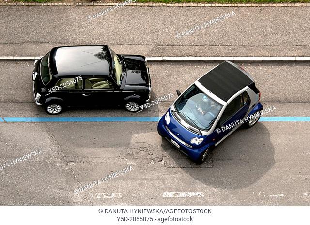 Smallest motor cars Mini Cooper and Smart next to each other on the street, parking zone, view from above