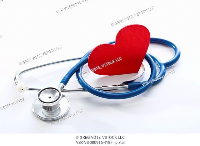 Stethoscope and red heart on white surface