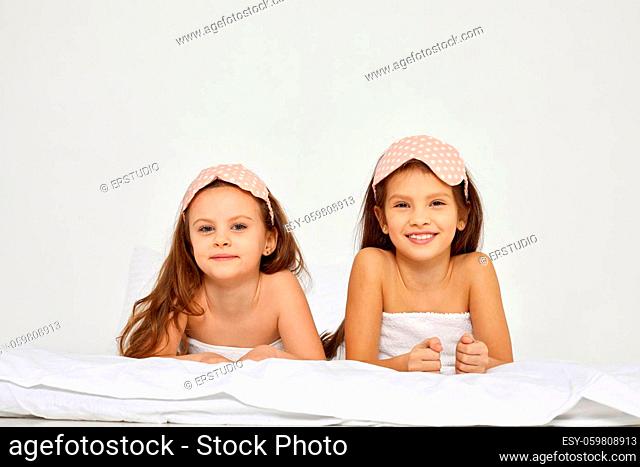 Two cute little child girls with towels on their heads in bedroom