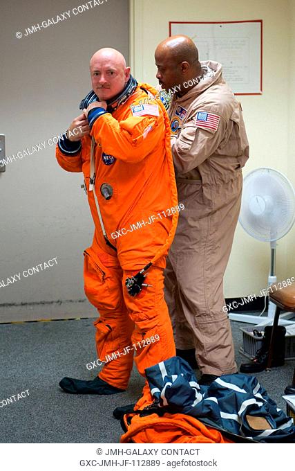NASA astronaut Mark Kelly, STS-134 commander, dons a training version of his shuttle launch and entry suit in preparation for a training session in the...