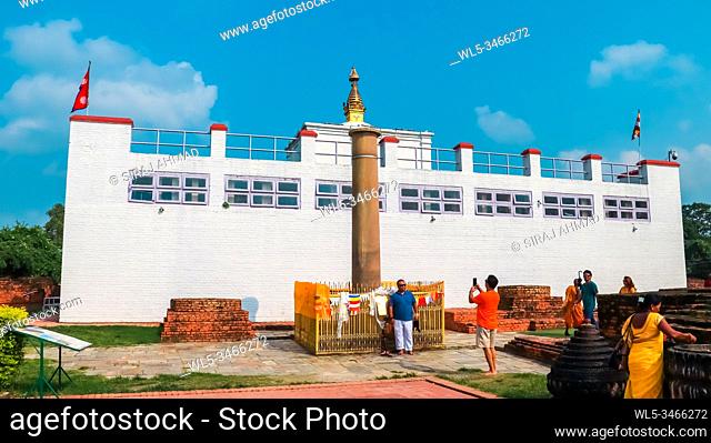 Lumbini, Nepal - September 15 2018: Buddhist Devotees circling Ashoka Pillar Stupa located beside Maya Devi Temple in Lumbini