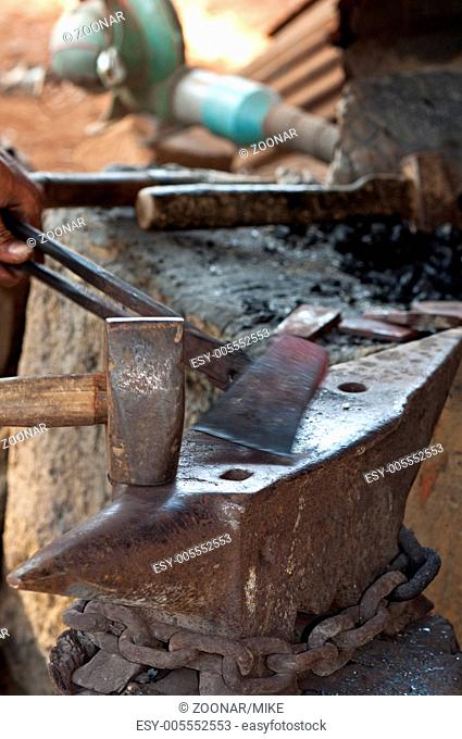 Forging a hammer head in a village forge