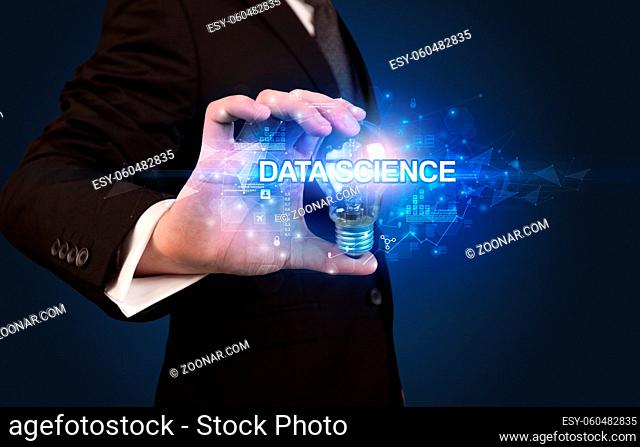 Businessman holding light bulb with DATA SCIENCE inscription, innovative technology concept