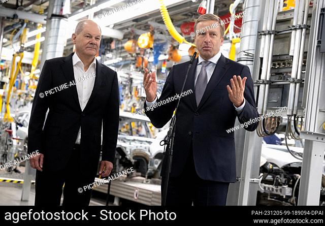 05 December 2023, Bavaria, Munich: Federal Chancellor Olaf Scholz (l, SPD) and Oliver Zipse, CEO of BMW, give a press statement after the visit to the BMW plant