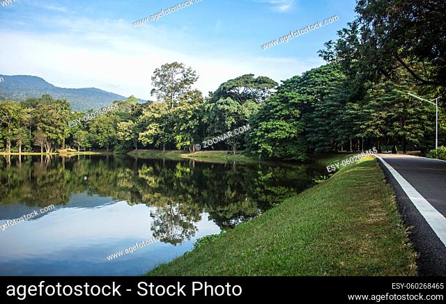 Horizontal photo of amazing view of the Ang Kaew Reservoir lake, surrounded by trees and mountain in the background. Chiang Mai, Thailand