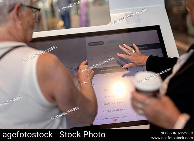 Women using touchscreen in shop